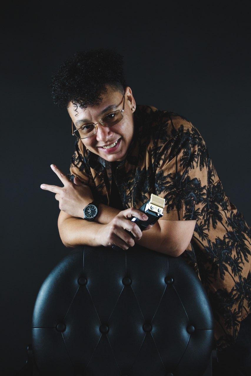 Victoria, barber at Victorious Cutz, posing with her clippers