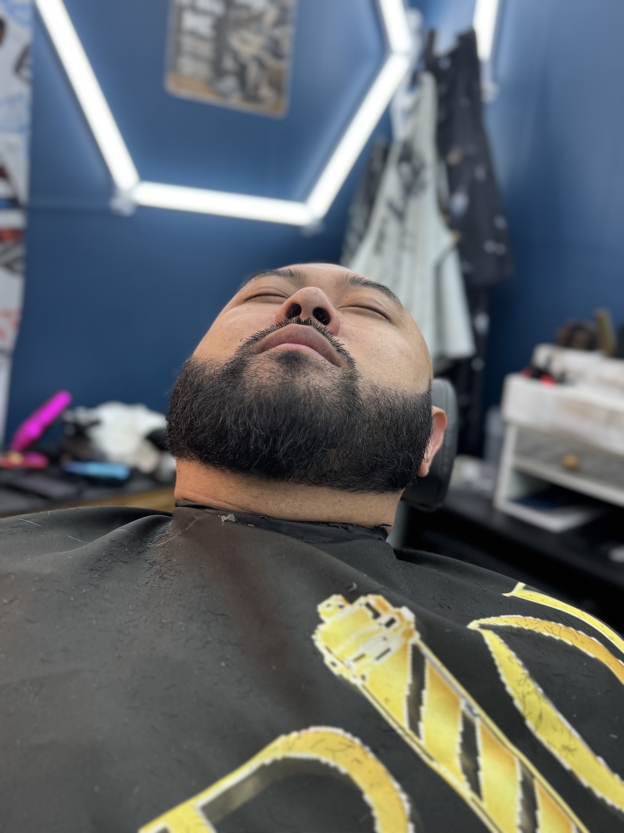 A beard trim finished in the shop's blue-walled room