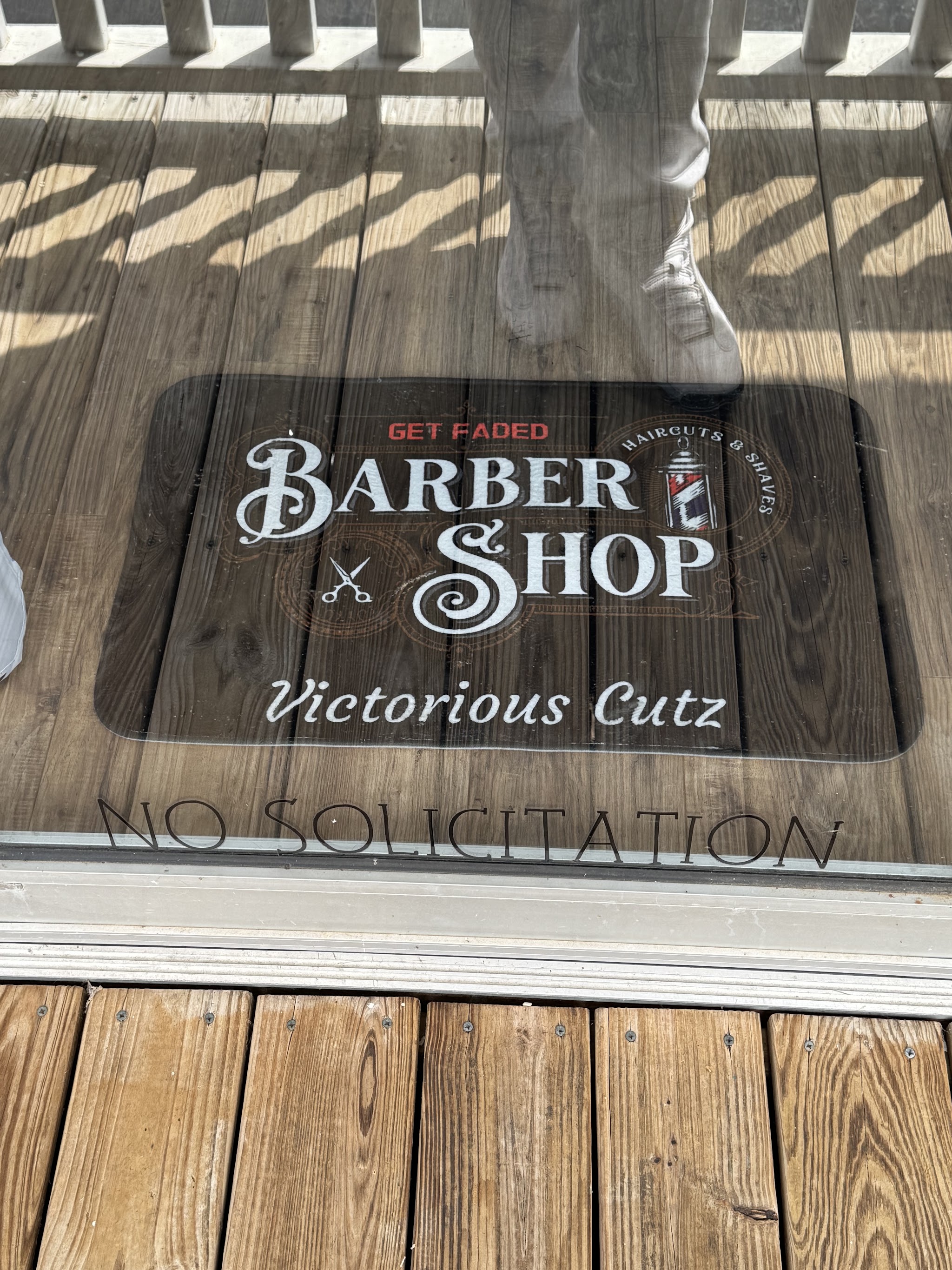 The Victorious Cutz barber shop doormat at the entrance