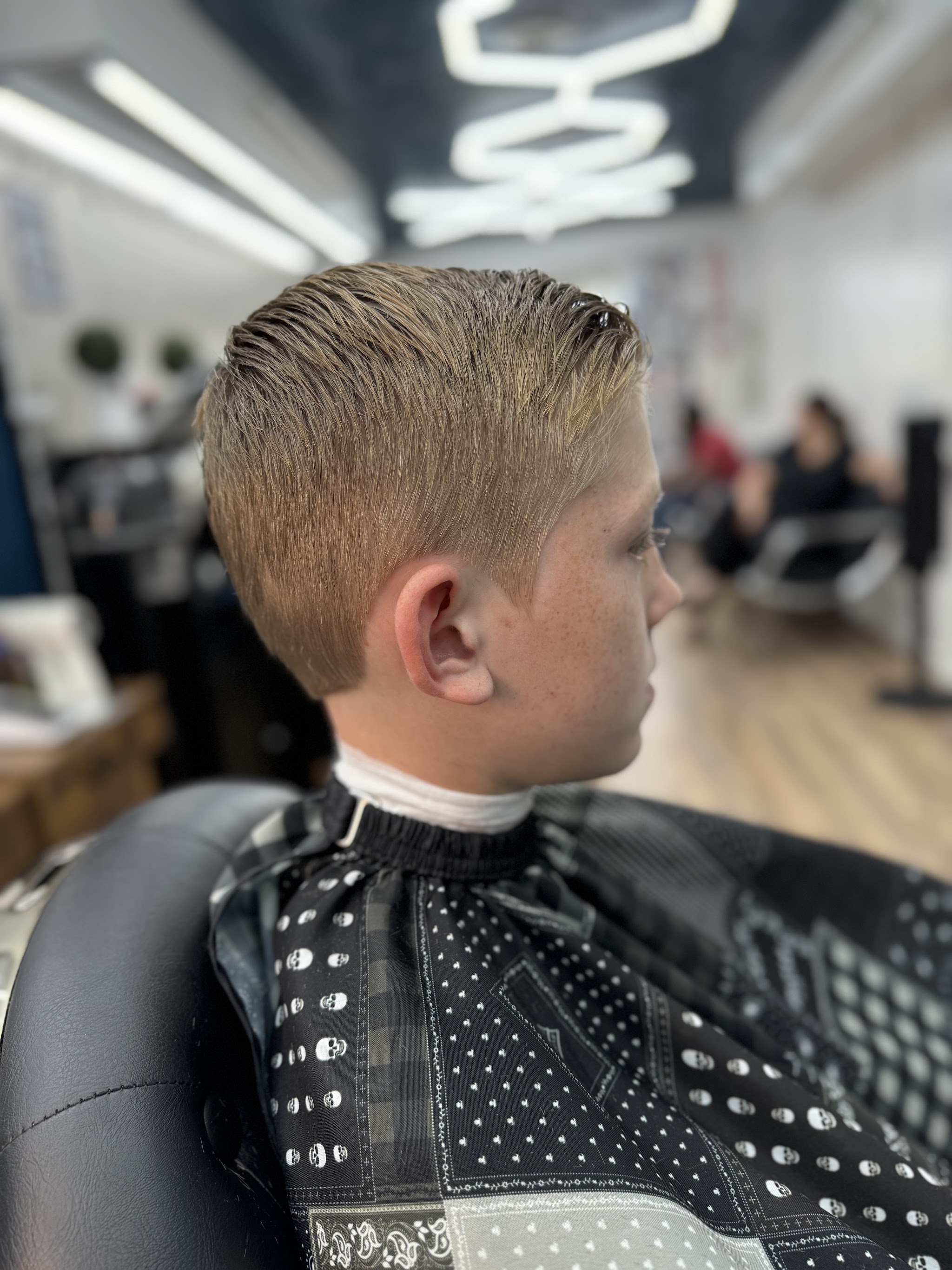 A boy's haircut with a neat side part
